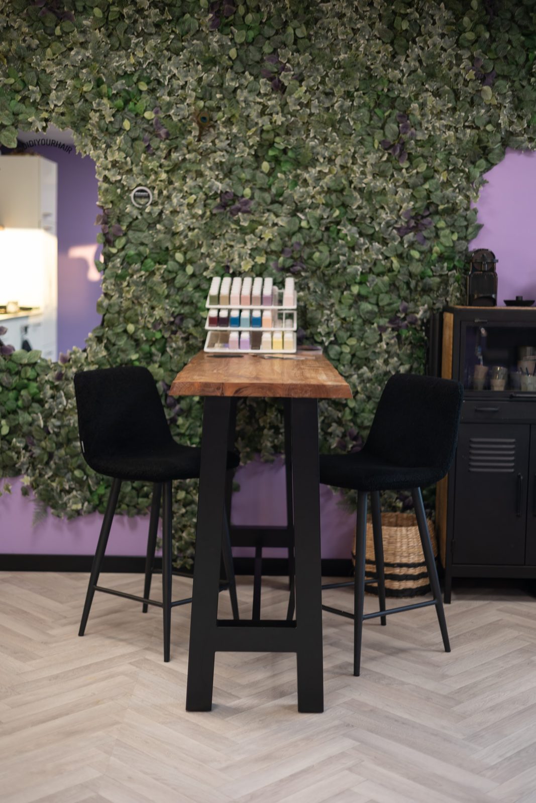 Een hoge tafel met twee krukken voor de klimopwand